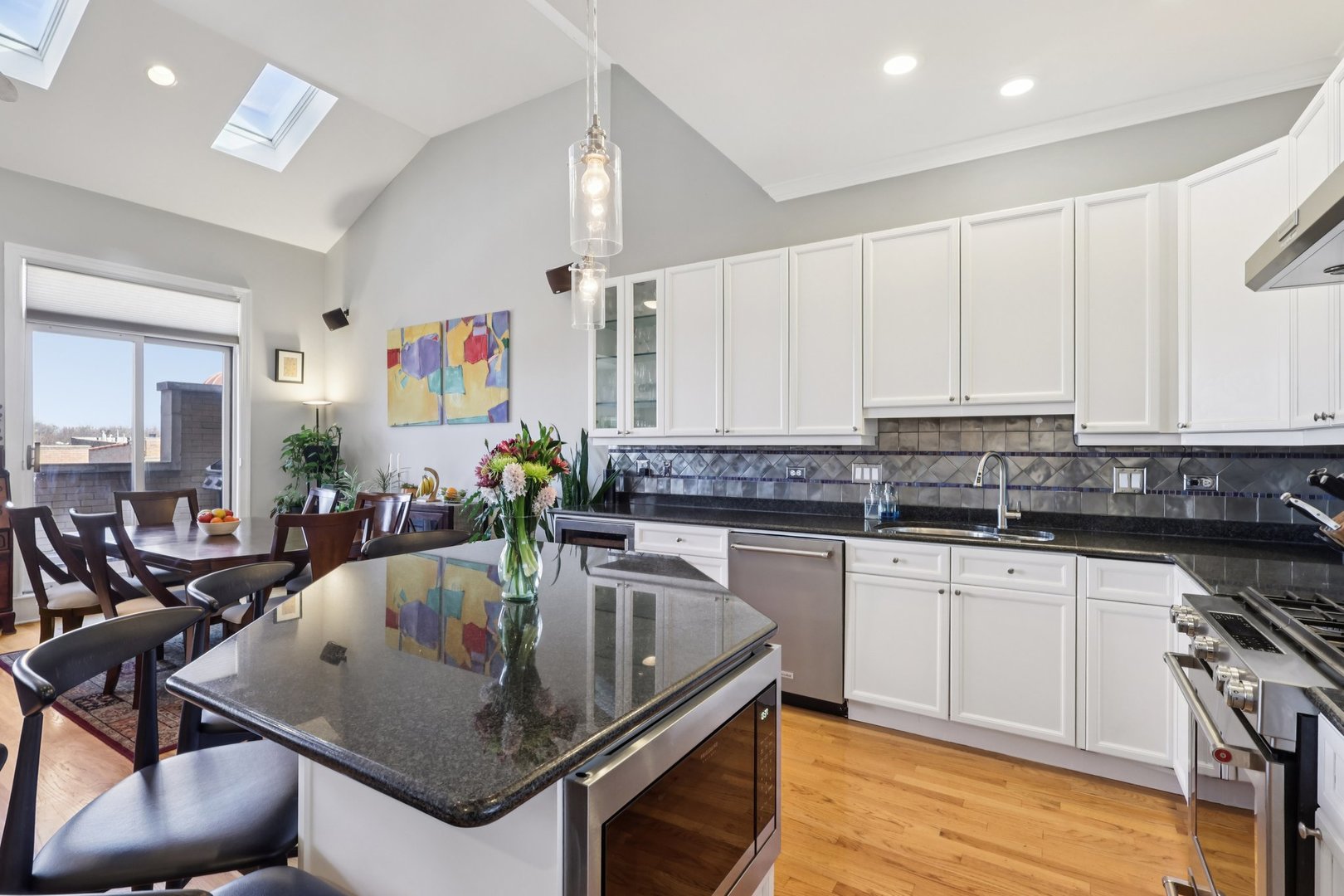 1473 West Irving Park Road, Unit 4E Chicago, IL 60613 - Photo 12 of 44 a kitchen with stainless steel appliances granite countertop a sink stove and cabinets