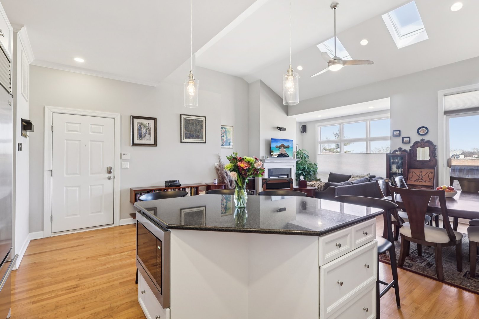 1473 West Irving Park Road, Unit 4E Chicago, IL 60613 - Photo 13 of 44 a kitchen with stainless steel appliances granite countertop a sink a counter space and living room view