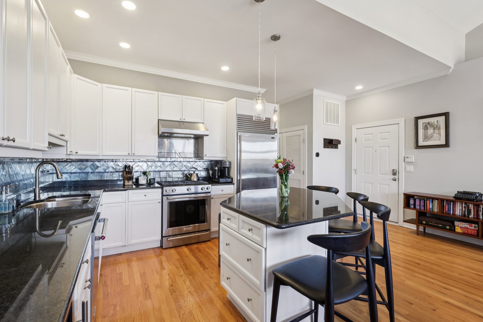 1473 West Irving Park Road, Unit 4E Chicago, IL 60613 - Photo 14 of 44 a kitchen with stainless steel appliances granite countertop a stove top oven a sink dishwasher a dining table and chairs with wooden floor