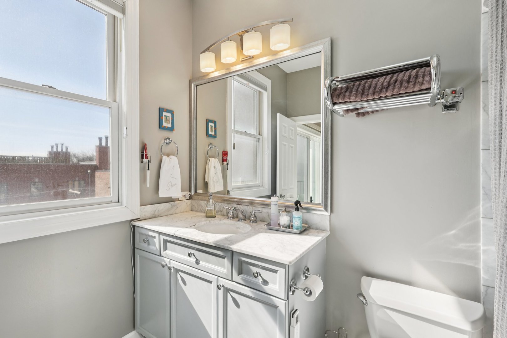 1473 West Irving Park Road, Unit 4E Chicago, IL 60613 - Photo 24 of 44 a bathroom with a sink a toilet and a mirror