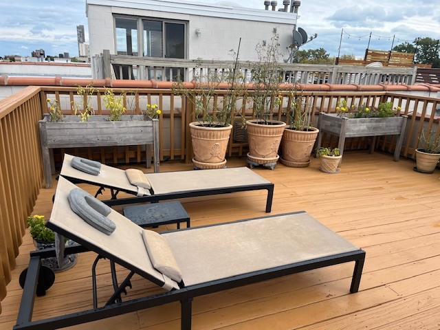 1473 West Irving Park Road, Unit 4E Chicago, IL 60613 - Photo 43 of 44 a view of a balcony with wooden floor and outdoor seating