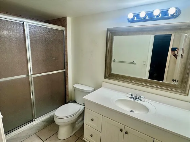 a bathroom with a sink a mirror a toilet and shower