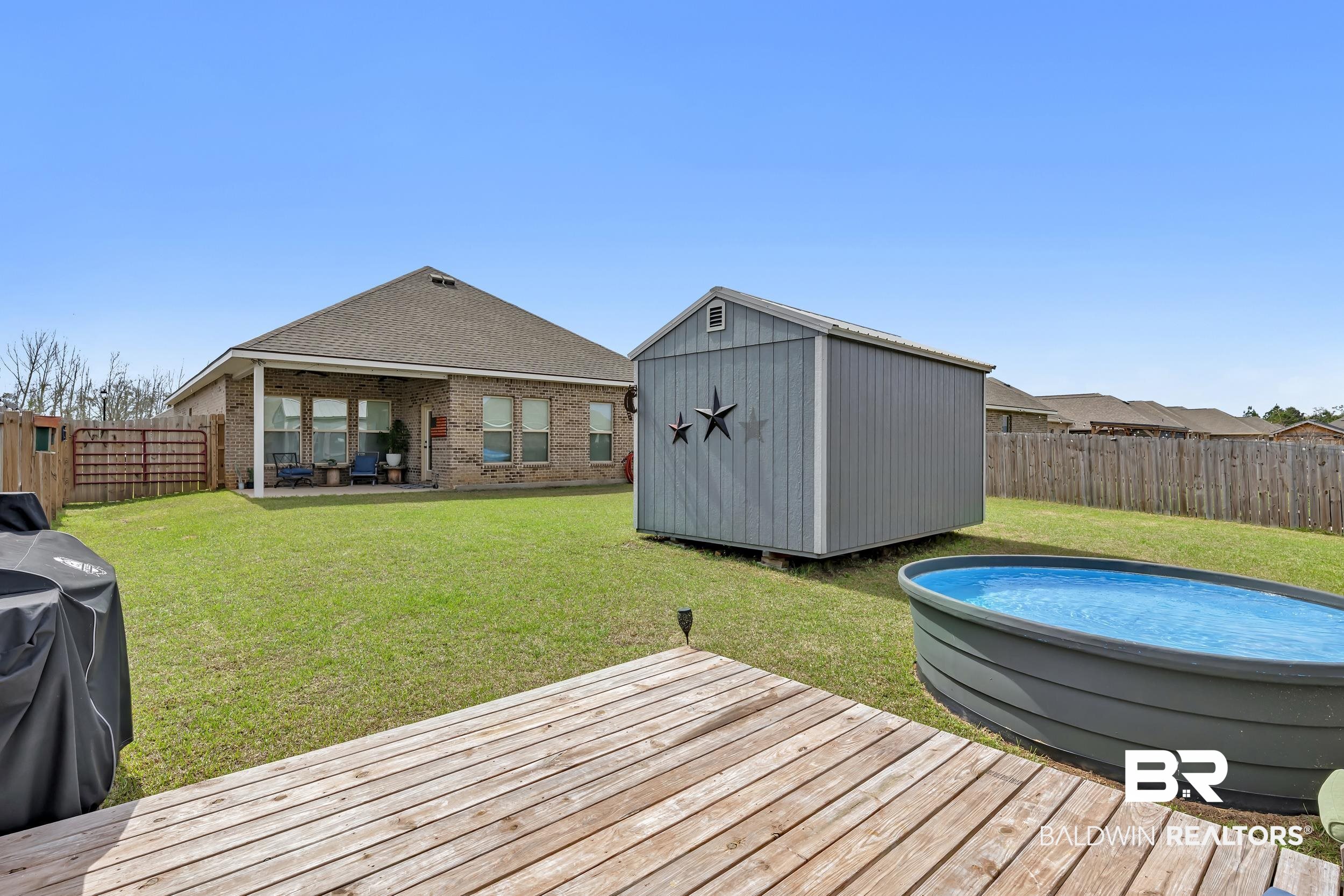 1176 Stella Road Foley, AL 36535 - Photo 37 of 40 Wooden terrace featuring a fenced backyard, a shed, and a patio