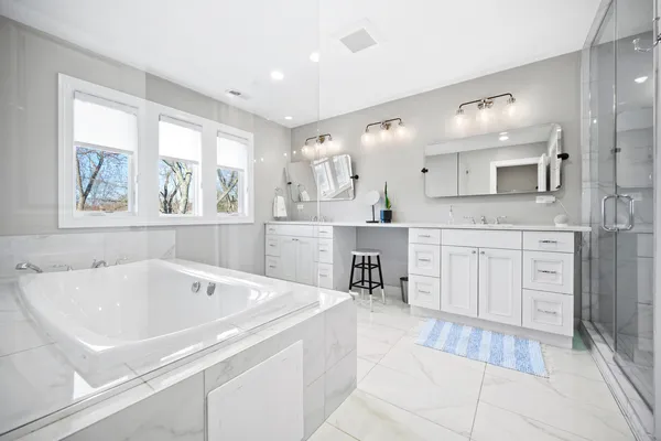 a spacious bathroom with a tub sink and mirror