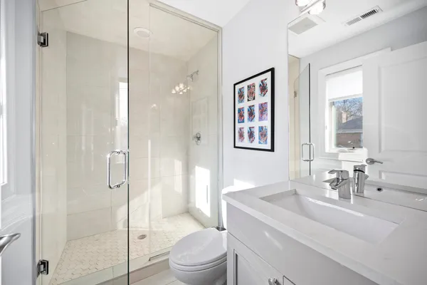 a bathroom with a sink a toilet and shower