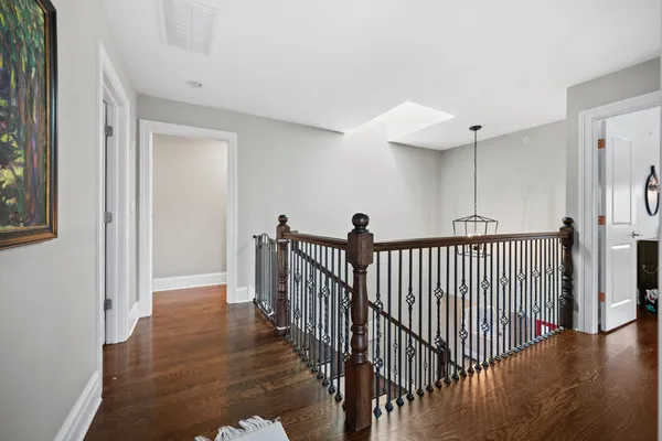 a view of a hallway with wooden floor and windows