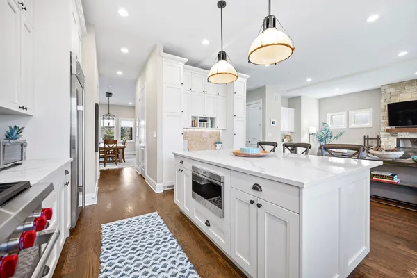 a kitchen with kitchen island granite countertop a sink a stove and a refrigerator