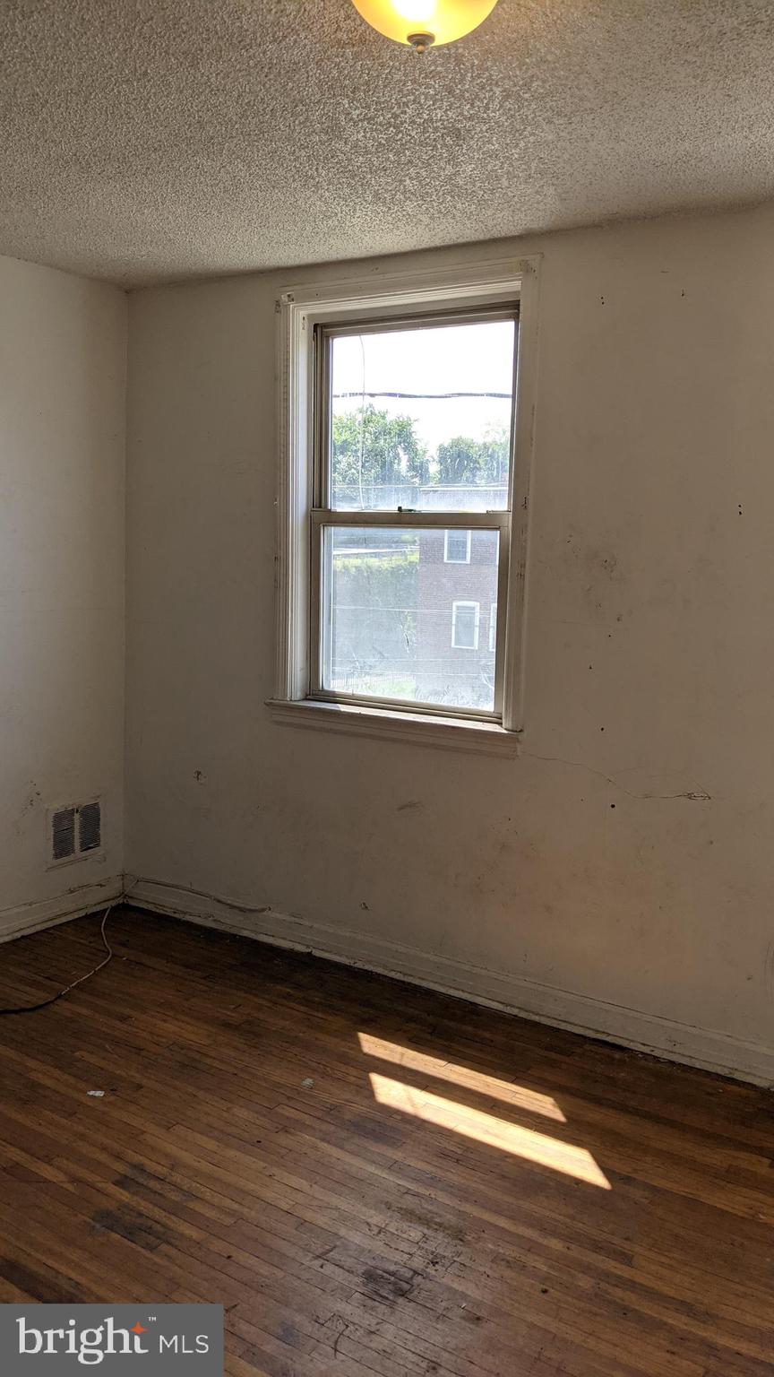 3162 Colorado Road Camden, NJ 08104 - Photo 10 of 21 a view of an empty room with wooden floor and a window