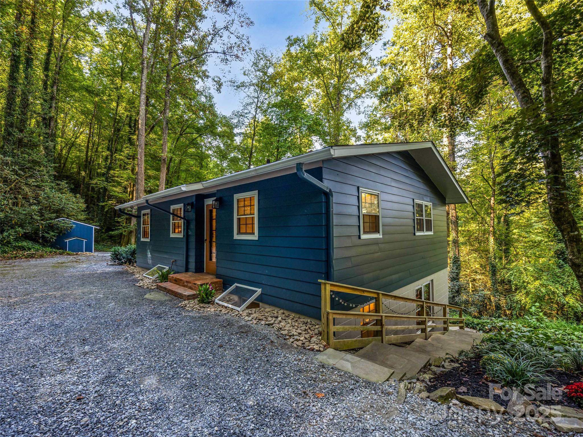 a view of a house with a yard and large trees