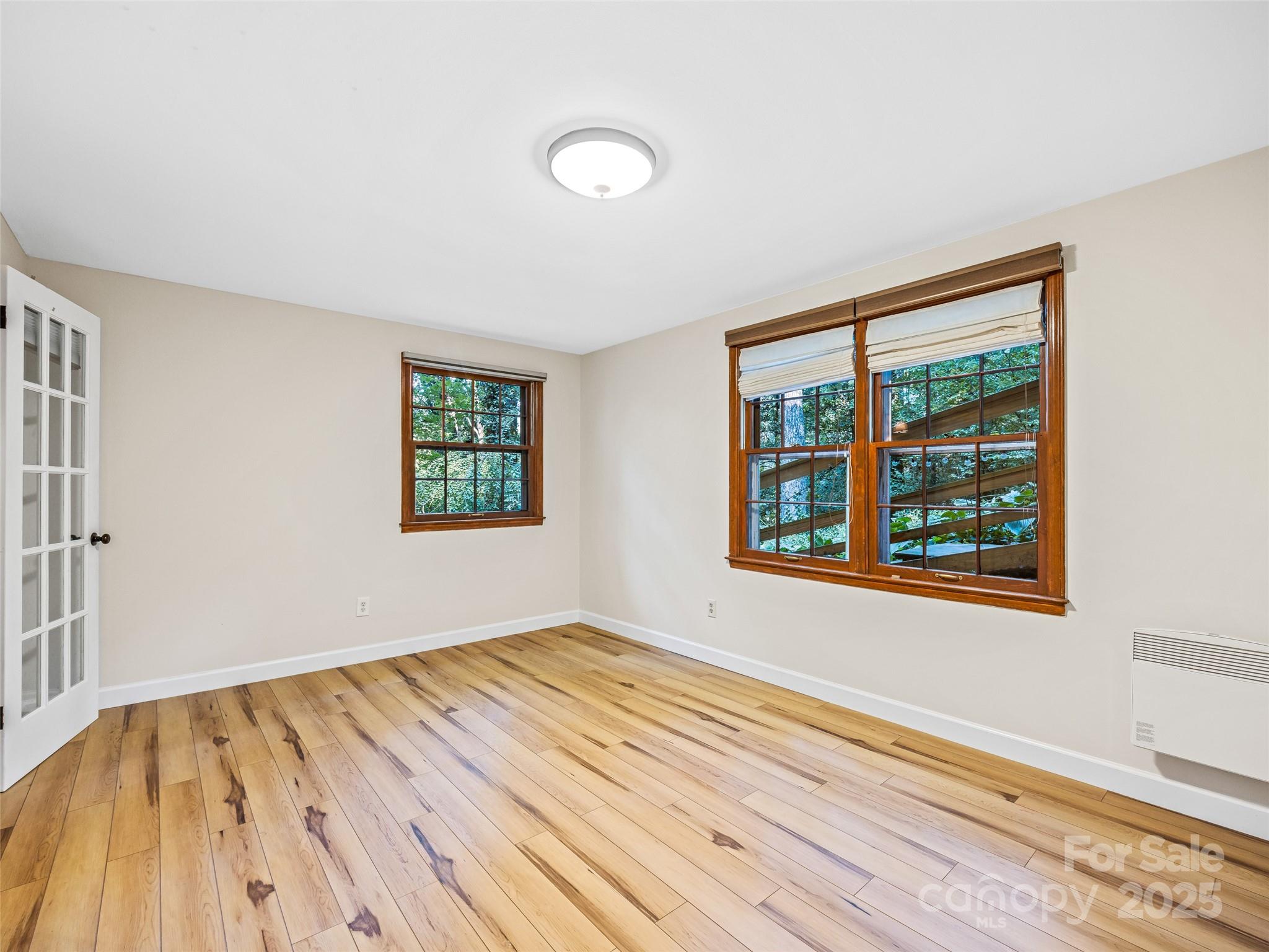 112 Top Of The Mountain Road Hendersonville, NC 28739 - Photo 12 of 28 a view of an empty room with wooden floor and a window