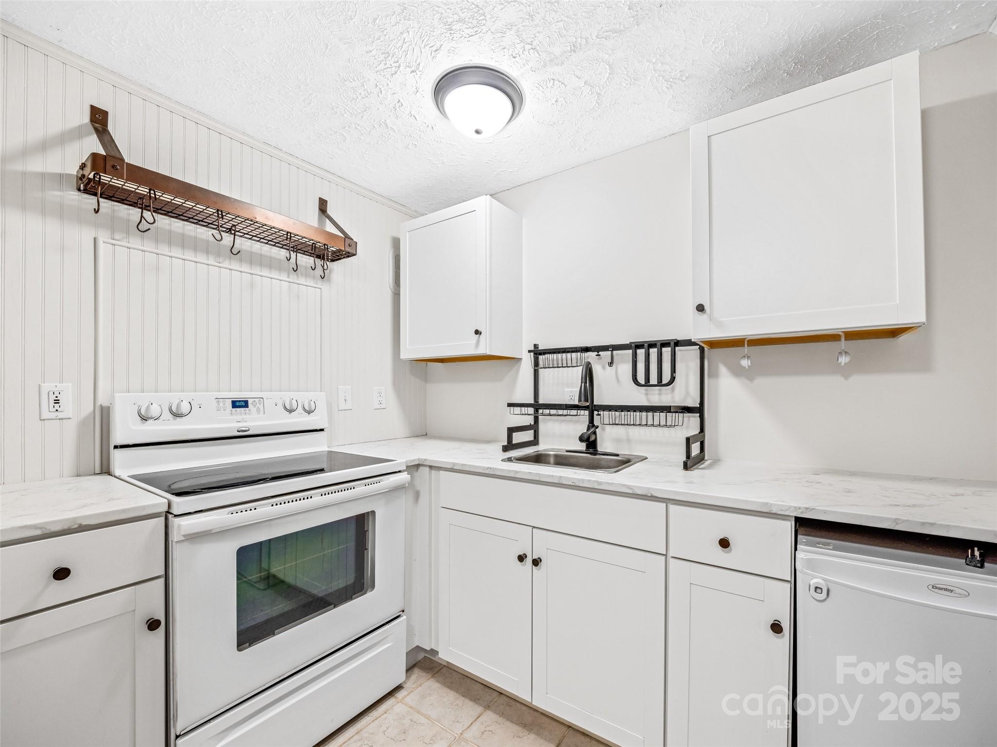 112 Top Of The Mountain Road Hendersonville, NC 28739 - Photo 16 of 28 a kitchen with white cabinets and white appliances