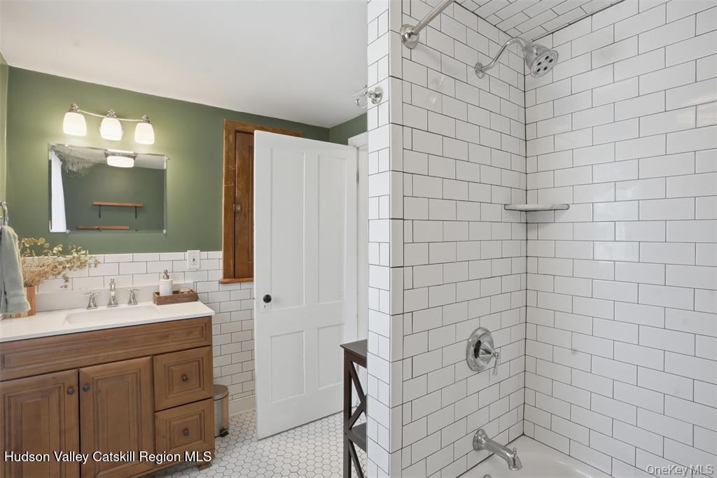 745 Springtown Road Tillson, NY 12486 - Photo 19 of 29 a bathroom with a double vanity sink a mirror and a shower