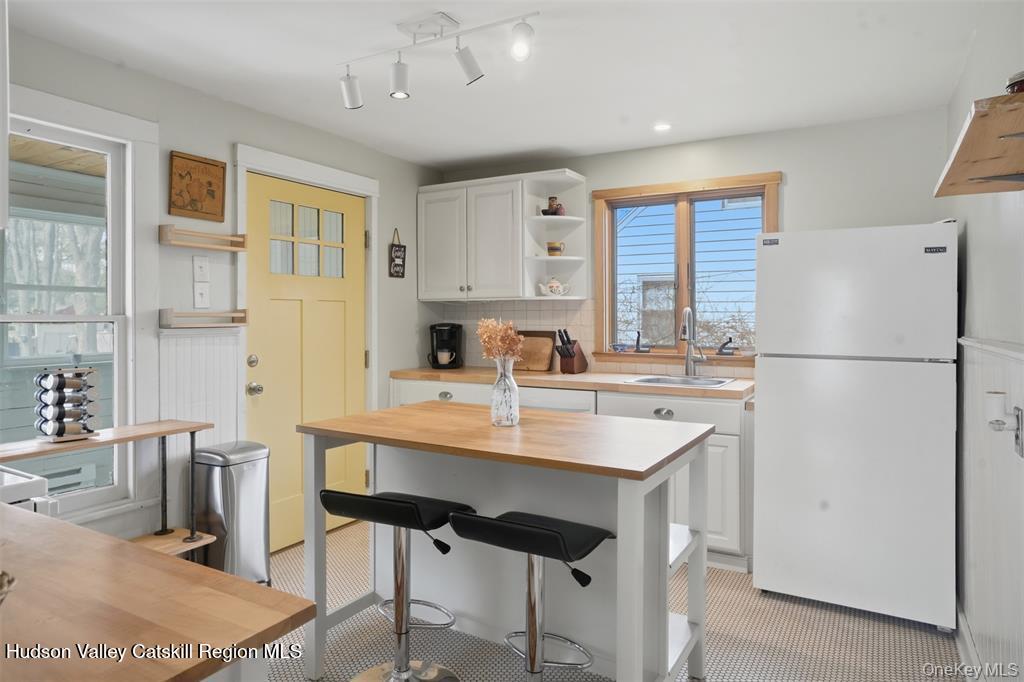 745 Springtown Road Tillson, NY 12486 - Photo 9 of 29 a kitchen with stainless steel appliances a sink a stove a refrigerator a dining table and chairs
