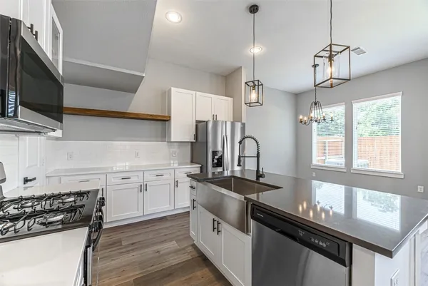 a kitchen with stainless steel appliances a sink stove and cabinets