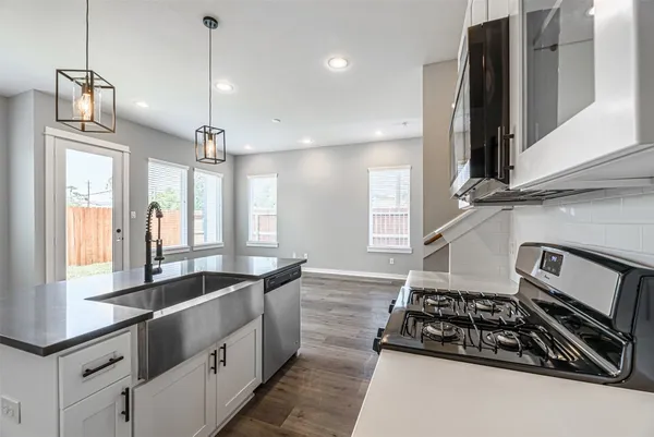 a kitchen with stainless steel appliances granite countertop a sink stove and refrigerator
