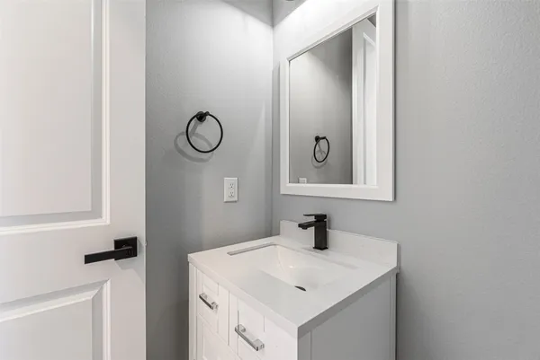 a bathroom with a toilet sink vanity and mirror