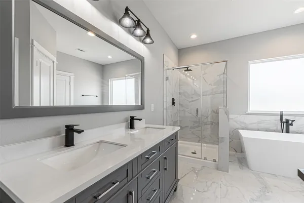 a bathroom with a double vanity sink a mirror a bathtub and shower