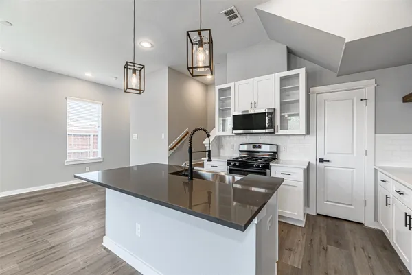 a kitchen with stainless steel appliances a stove microwave and sink