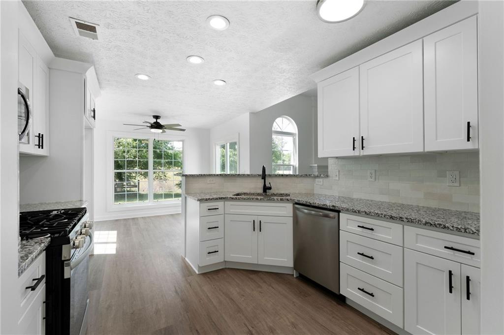 20 Mallet Pointe Street Northeast Cartersville, GA 30121 - Photo 10 of 37 a kitchen with granite countertop white cabinets and white appliances