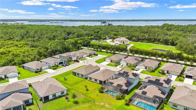 an aerial view of residential houses with outdoor space and trees