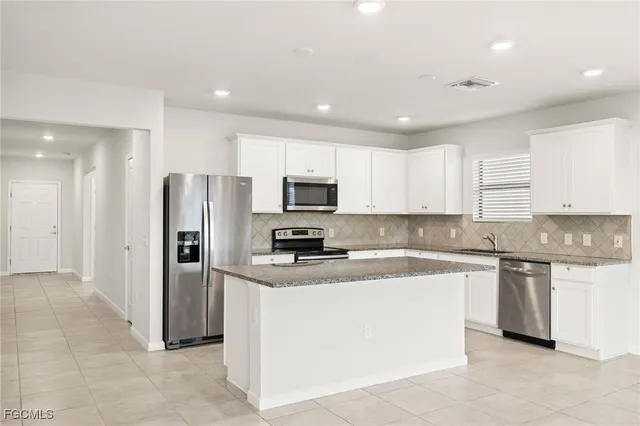 a kitchen with stainless steel appliances granite countertop a refrigerator sink and cabinets