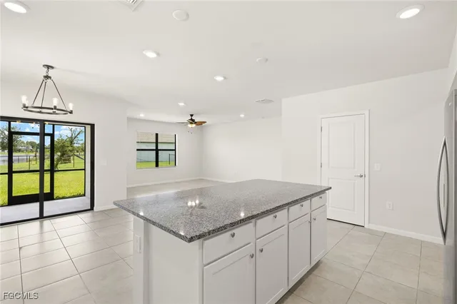 a kitchen with granite countertop a sink a stove and cabinets