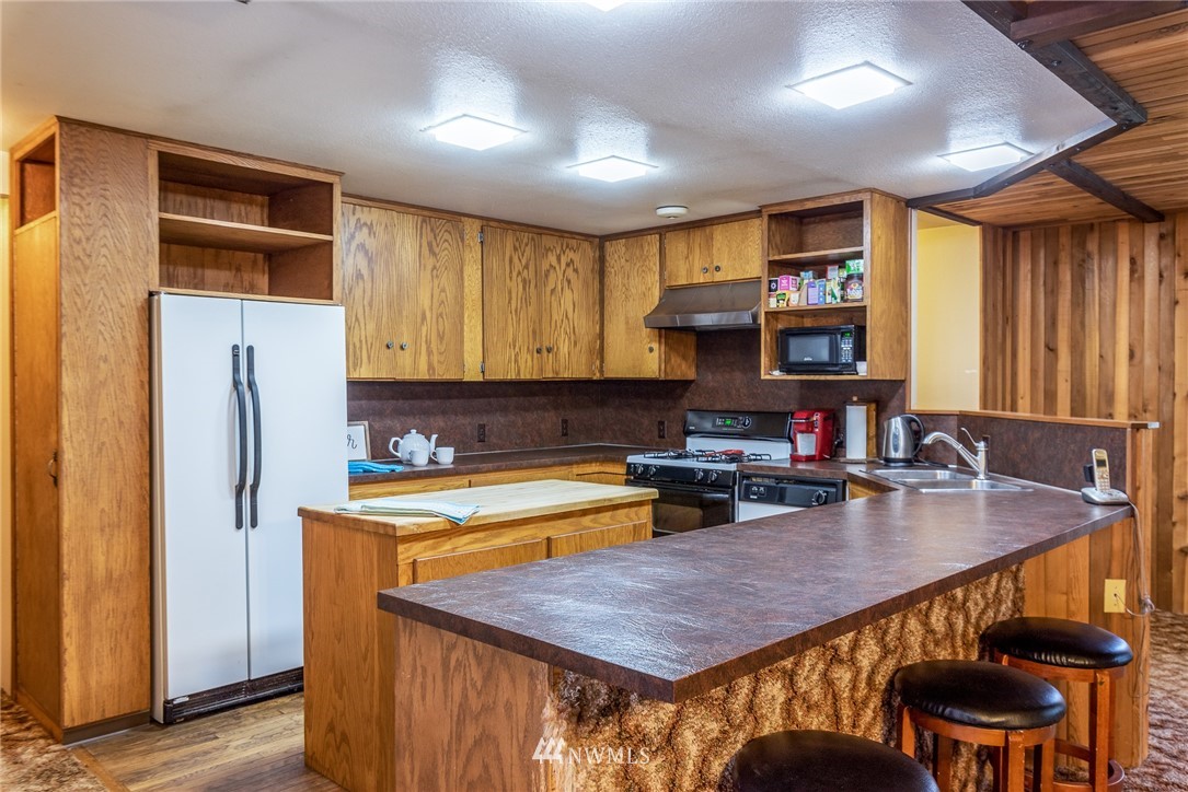 6130 North Fork Road Deming, WA 98244 - Photo 11 of 22 a kitchen with a table chairs sink refrigerator and cabinets