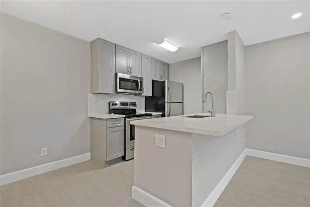 a kitchen with kitchen island a sink stainless steel appliances and cabinets