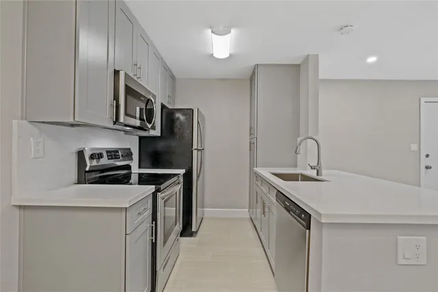 a kitchen with stainless steel appliances granite countertop a sink stove and refrigerator