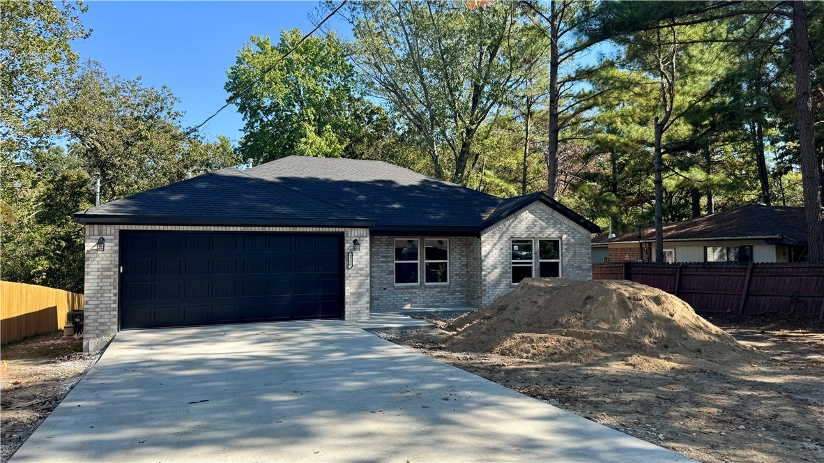 1300 Coler Drive Pea Ridge, AR 72751 - Photo 2 of 3 Brick exterior with dark roof, two-car garage, and concrete driveway