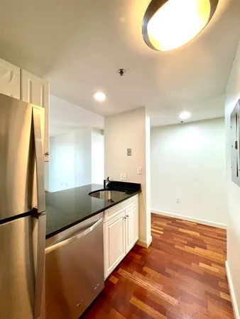 a kitchen with granite countertop a refrigerator and a sink