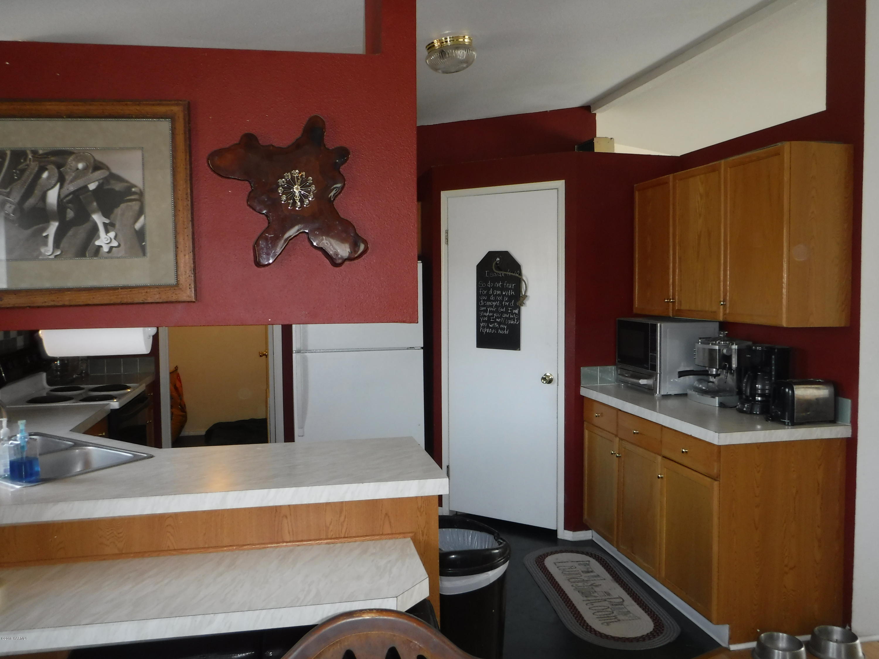 495 Burnham Road Yakima, WA 98908 - Photo 27 of 36 a kitchen with stainless steel appliances a sink a stove and a refrigerator with wooden floor