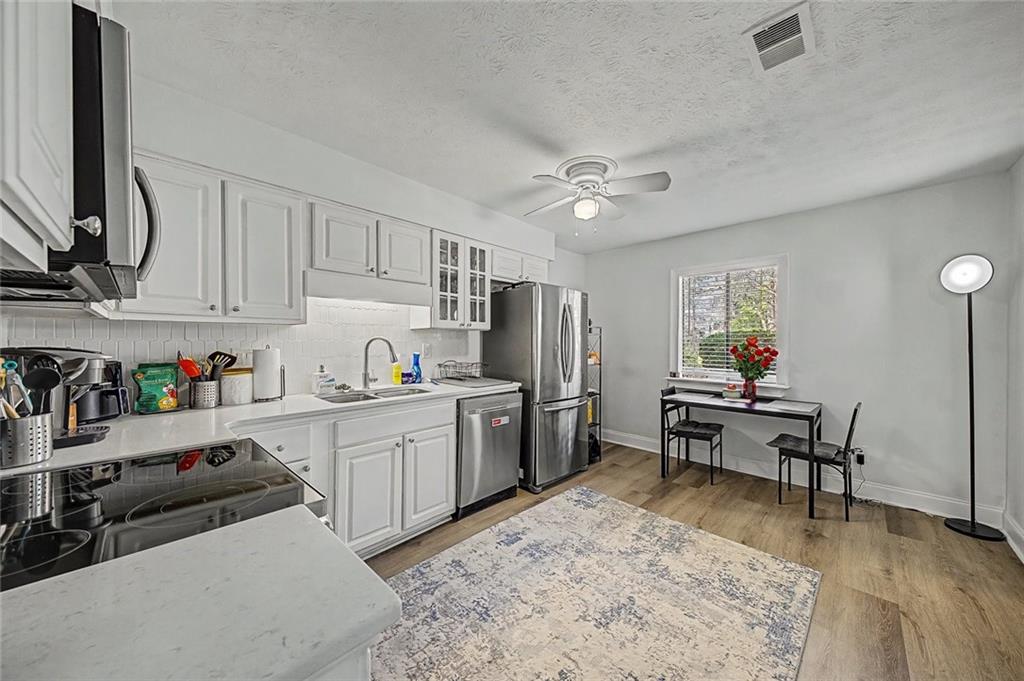 a living room with stainless steel appliances kitchen island granite countertop furniture and a wooden floors