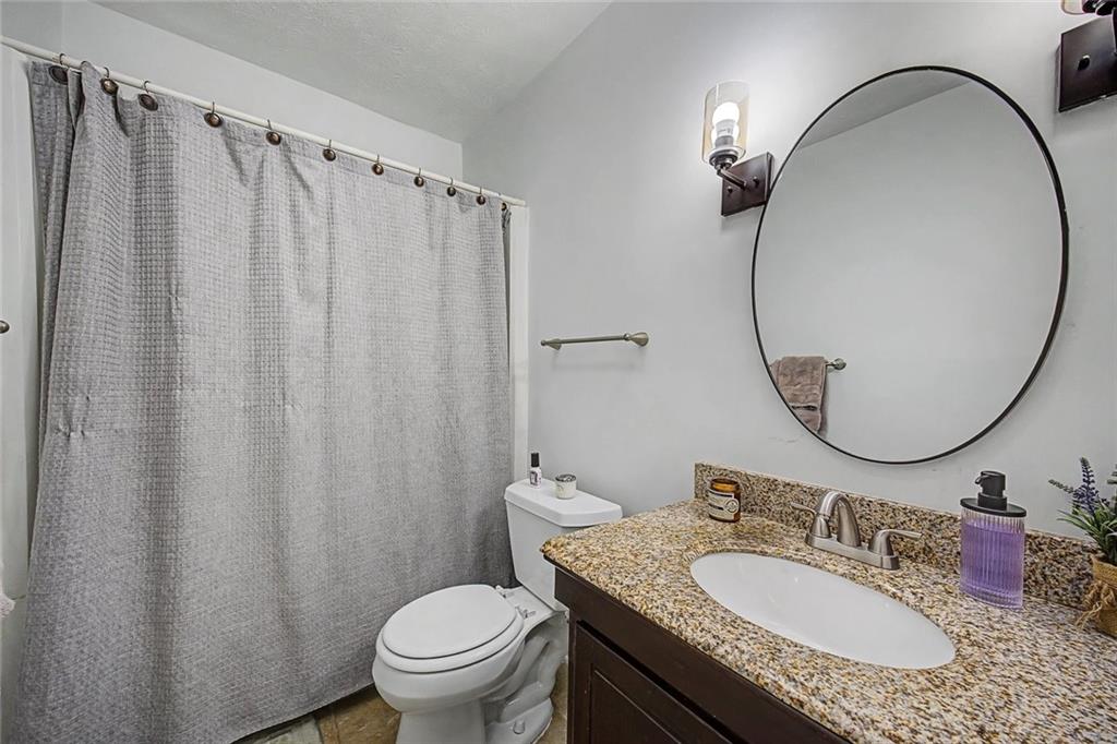 2911 Ironwood Road Southeast Marietta, GA 30067 - Photo 12 of 32 a bathroom with a granite countertop sink toilet and a mirror