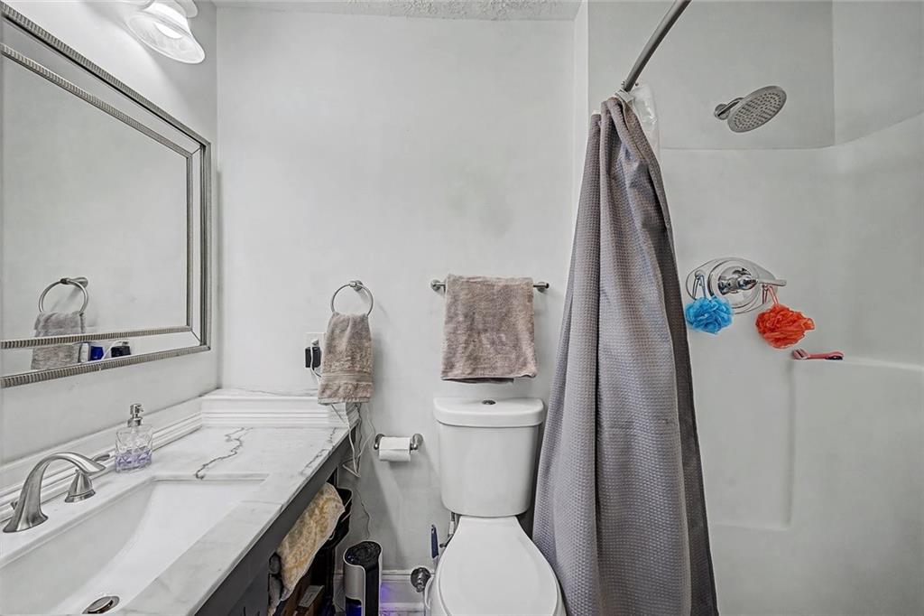 2911 Ironwood Road Southeast Marietta, GA 30067 - Photo 16 of 32 a bathroom with a sink vanity mirror and toilet