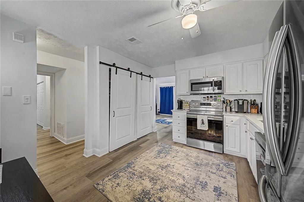2911 Ironwood Road Southeast Marietta, GA 30067 - Photo 7 of 32 a kitchen with white cabinets and stainless steel appliances