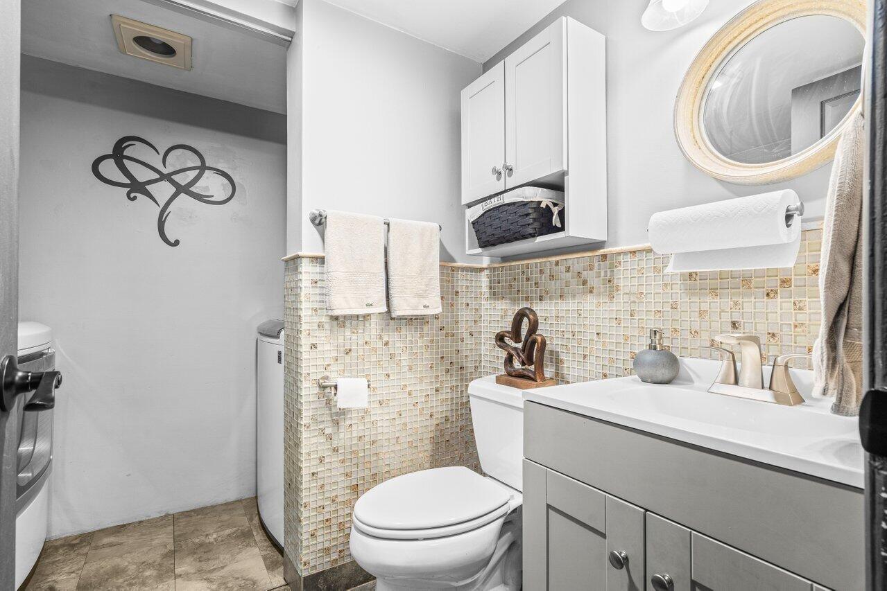 22180 Boca Rancho Drive, Unit B Boca Raton, FL 33428 - Photo 11 of 22 a bathroom with a toilet sink vanity granite and a mirror