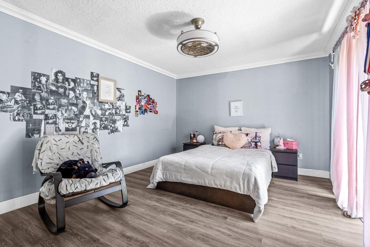 22180 Boca Rancho Drive, Unit B Boca Raton, FL 33428 - Photo 17 of 22 a bedroom with a bed and a chandelier