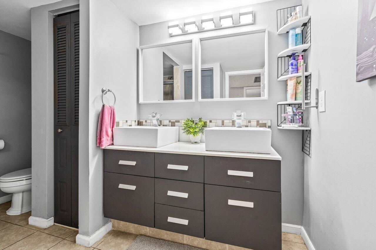 22180 Boca Rancho Drive, Unit B Boca Raton, FL 33428 - Photo 21 of 22 a bathroom with a sink vanity and a mirror