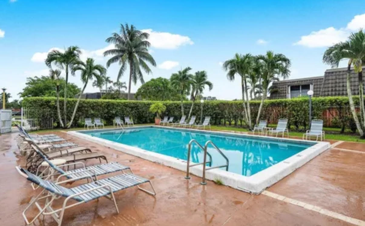22180 Boca Rancho Drive, Unit B Boca Raton, FL 33428 - Photo 22 of 22 a view of a swimming pool with a patio and a garden
