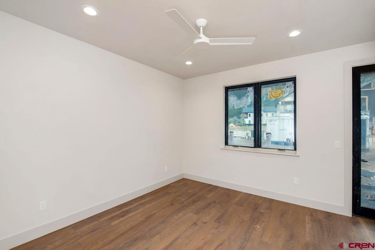 180 Elk Valley Road, Unit 124 Crested Butte, CO 81224 - Photo 12 of 23 an empty room with wooden floor and windows