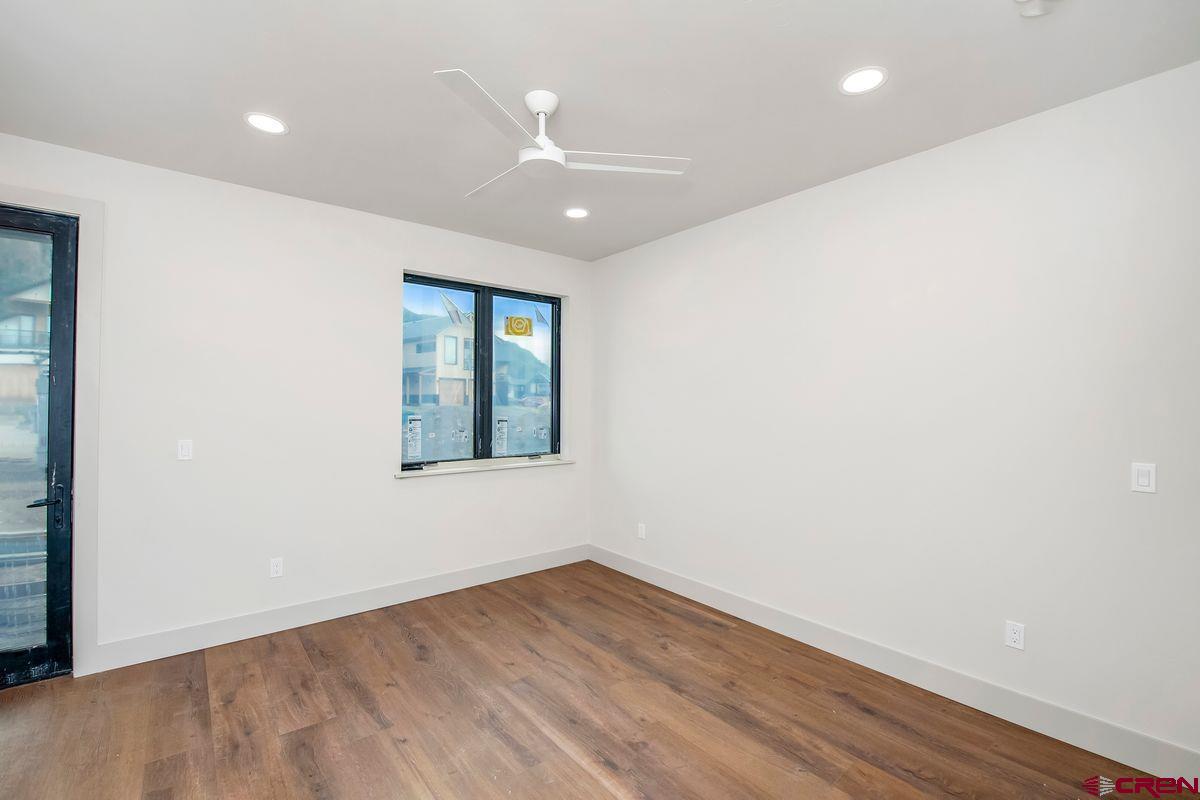 180 Elk Valley Road, Unit 124 Crested Butte, CO 81224 - Photo 14 of 23 an empty room with wooden floor and windows