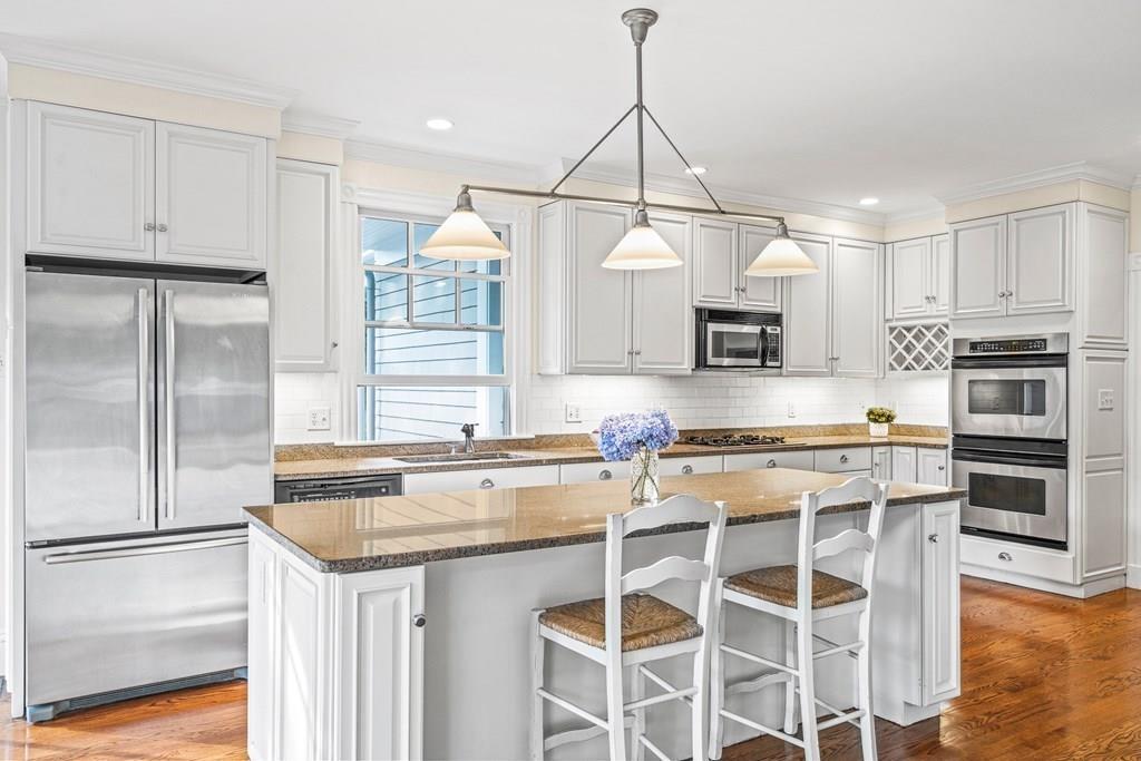 8 Garden Road Wellesley, MA 02481 - Photo 13 of 30 a kitchen with kitchen island granite countertop a sink cabinets stainless steel appliances and a counter top space