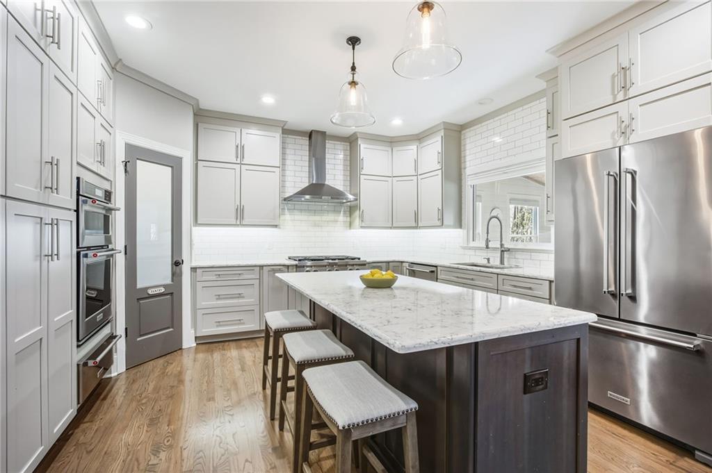 5318 Tallgrass Way Kennesaw, GA 30152 - Photo 19 of 70 a kitchen with kitchen island a refrigerator stove microwave and cabinets