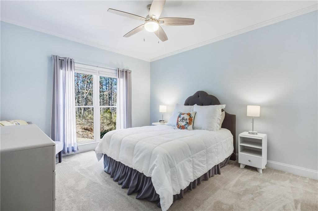 5318 Tallgrass Way Kennesaw, GA 30152 - Photo 27 of 70 a bedroom with a large bed and a chandelier fan