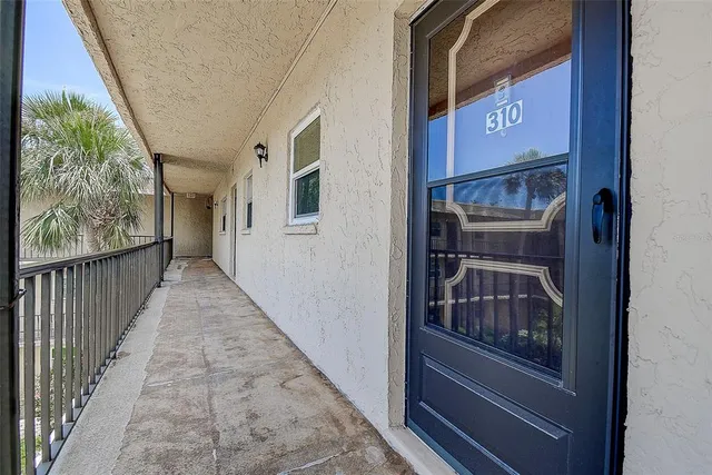 a view of a hallway with wooden floor and windows