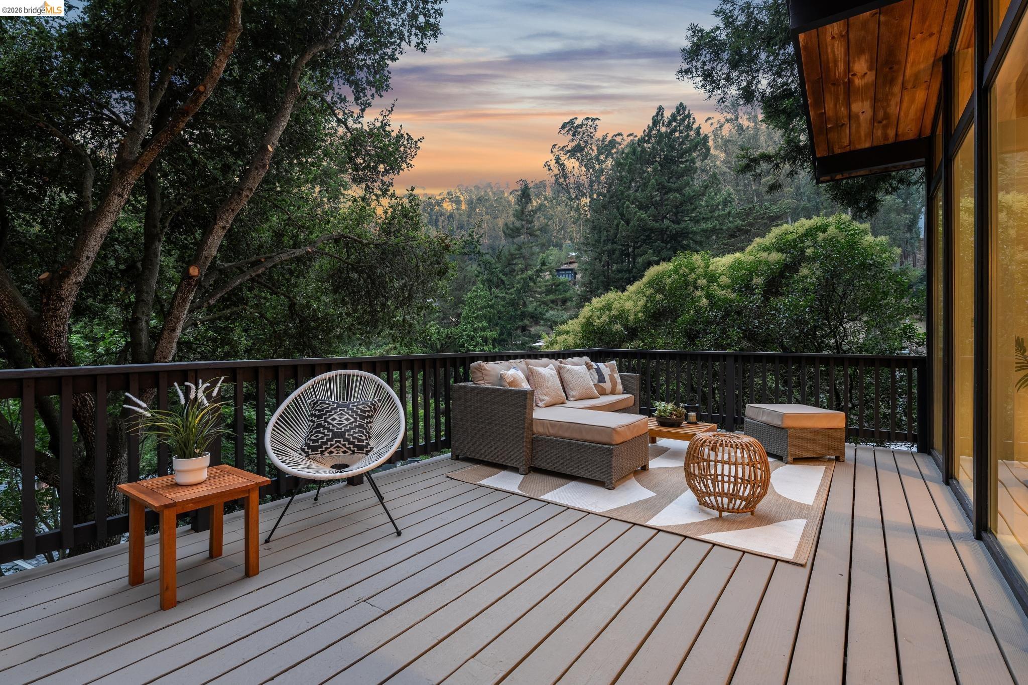 6645 Heather Ridge Way Oakland, CA 94611 - Photo 40 of 61 Spacious outdoor deck with a dark wood railing, offering expansive tree-lined surroundings