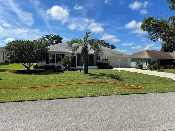 a front view of a house with a yard and trees