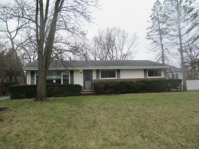 a front view of a house with a yard and trees