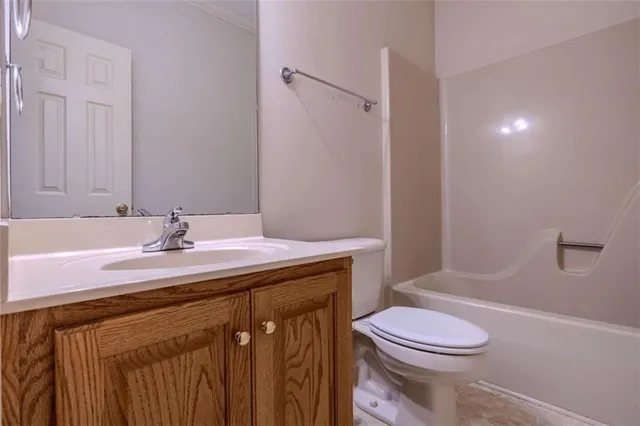 a bathroom with a sink a toilet a mirror and shower